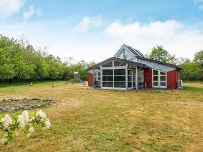a red house with a playground in a field at 6 person holiday home in Vemb-By Traum in Vemb