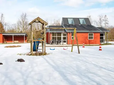 a playground in the snow in front of a house at 6 person holiday home in Vemb-By Traum in Vemb