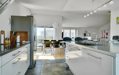 a kitchen with white cabinets and a dining room at Lovely Home In Thisted With Kitchen in Thisted