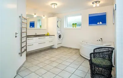 a bathroom with a tub and a sink and a washing machine at Lovely Home In Thisted With Kitchen in Thisted