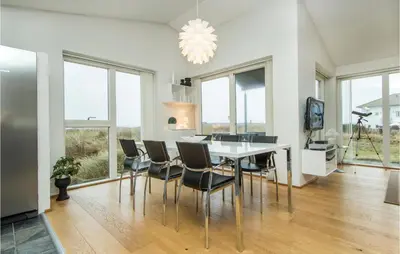 a dining room with a table and chairs and windows at Lovely Home In Thisted With Kitchen in Thisted