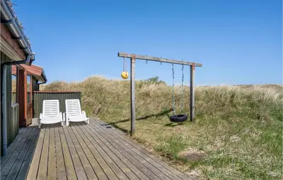 two chairs and a swing on a wooden deck at Beautiful Home In Løkken With Wifi in Løkken