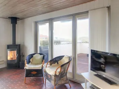 a living room with two chairs and a tv and a fireplace at Holiday Home Ågot - 75m from the sea by Interhome in Torsted