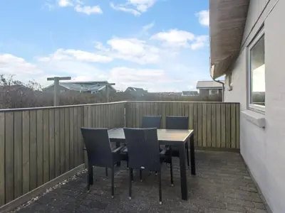 a table and chairs on a balcony with a fence at Holiday Home Ågot - 75m from the sea by Interhome in Torsted