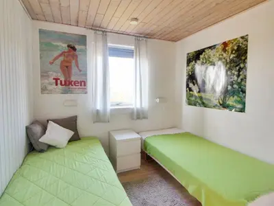 a bedroom with two green beds and a window at Holiday Home Ågot - 75m from the sea by Interhome in Torsted