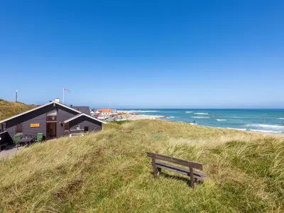 a bench sitting on top of a hill near the ocean at Holiday Home Arngrim - 100m from the sea by Interhome in Torsted