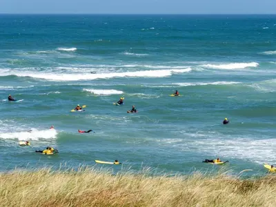 a group of people in the ocean on surfboards at Holiday Home Arngrim - 100m from the sea by Interhome in Torsted