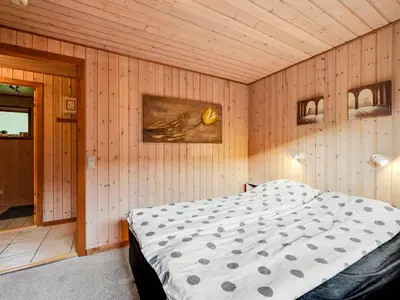 a bedroom with a bed in a wooden wall at Holiday Home Engeline - 300m to the fjord by Interhome in Vemb