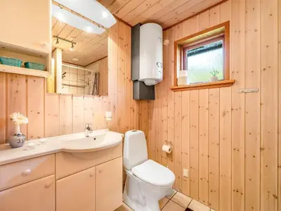a bathroom with a toilet and a sink at Holiday Home Engeline - 300m to the fjord by Interhome in Vemb
