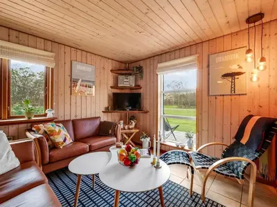 a living room with a couch and a table at Holiday Home Engeline - 300m to the fjord by Interhome in Vemb