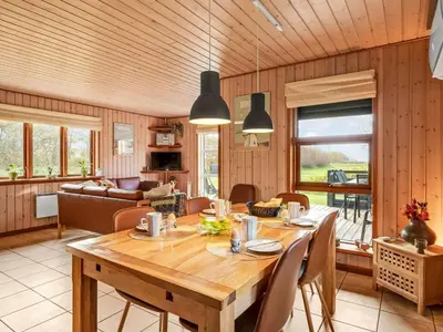a dining room with a wooden table and chairs at Holiday Home Engeline - 300m to the fjord by Interhome in Vemb