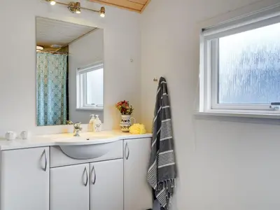a bathroom with a sink and a mirror at Holiday Home Daina - 400m to the fjord by Interhome in Vemb