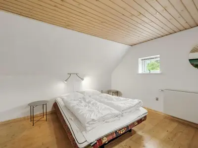 a white bedroom with a bed and a table at Holiday Home Wilmar - 1km to the fjord by Interhome in Vemb