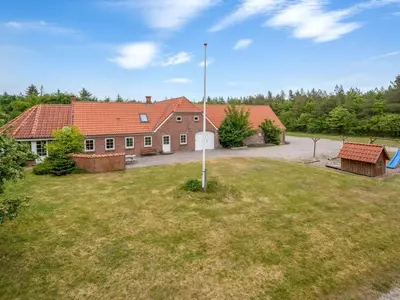 a building with a grassy yard in front of it at Holiday Home Wilmar - 1km to the fjord by Interhome in Vemb