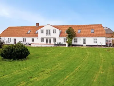 a large white house with a large green field at Holiday Home Thorge - 75m to the fjord by Interhome in Struer