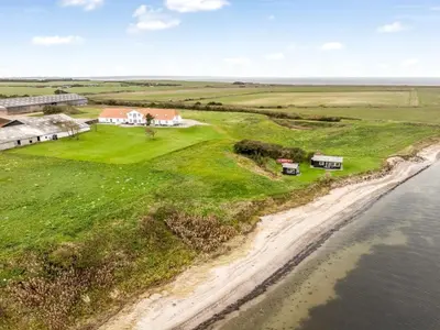 an aerial view of a house on a beach next to the water at Holiday Home Thorge - 75m to the fjord by Interhome in Struer