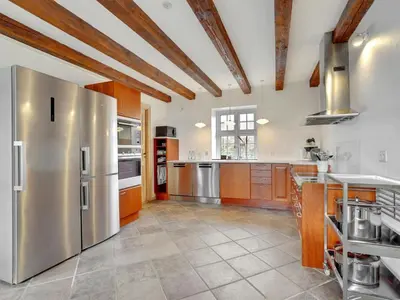 a large kitchen with stainless steel appliances and wooden cabinets at Holiday Home Thorge - 75m to the fjord by Interhome in Struer