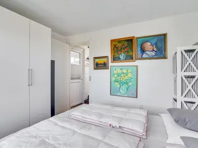 a bedroom with a bed and paintings on the wall at Holiday Home Tomine - 500m to the fjord by Interhome in Struer
