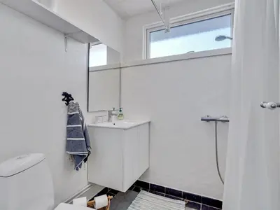 a white bathroom with a sink and a shower at Holiday Home Tomine - 500m to the fjord by Interhome in Struer