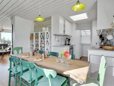 a kitchen and dining room with a wooden table and chairs at Holiday Home Tomine - 500m to the fjord by Interhome in Struer