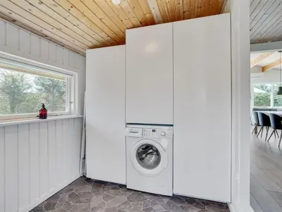 a washer and dryer in a white room with a window at Holiday Home Matilde - 400m to the fjord by Interhome in Struer