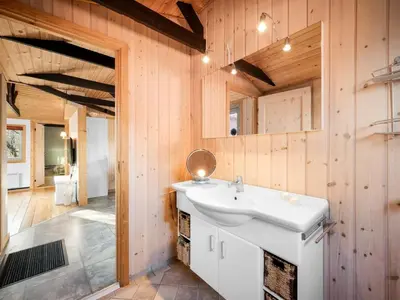 a bathroom with a white sink and wooden walls at Holiday Home Alpi - 250m to the fjord by Interhome in Struer