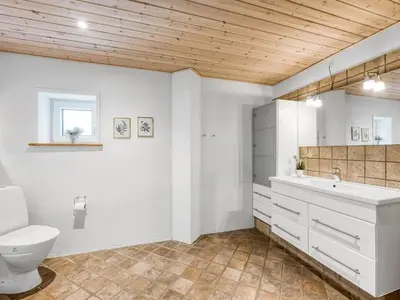 a white bathroom with a toilet and a sink at Holiday Home Ginny - 300m to the fjord by Interhome in Struer