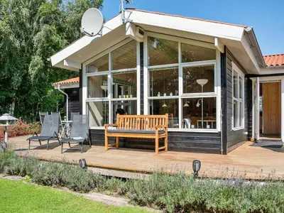 a house with a bench on a wooden deck at Holiday Home Kai - 500m to the fjord by Interhome in Struer