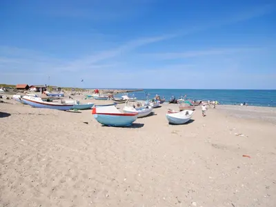 a group of boats sitting on a sandy beach at Holiday Home Biriel - 1km from the sea by Interhome in Thisted