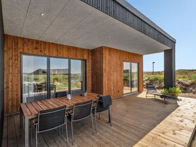 a wooden deck with a table and chairs on it at Holiday Home Trpana - 1-6km from the sea by Interhome in Thisted
