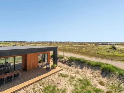 a house in the desert with a black roof at Holiday Home Trpana - 1-6km from the sea by Interhome in Thisted