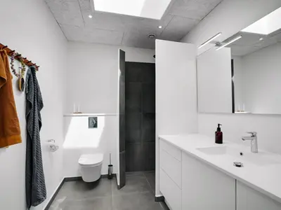 a white bathroom with a sink and a toilet at Holiday Home Trpana - 1-6km from the sea by Interhome in Thisted