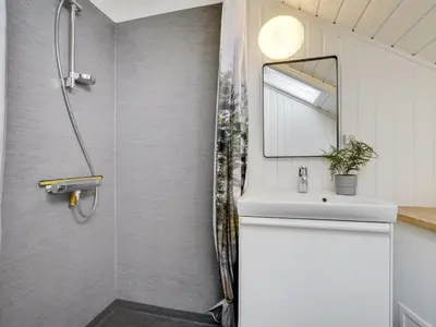 a bathroom with a shower and a sink and a mirror at Holiday Home Hjalmara - 900m from the sea by Interhome in Thisted