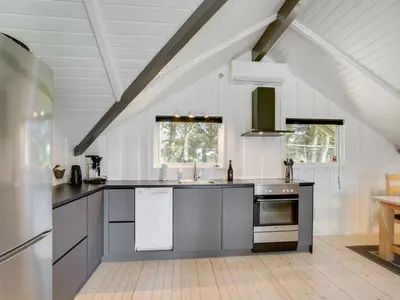 a kitchen with stainless steel appliances in a attic at Holiday Home Hjalmara - 900m from the sea by Interhome in Thisted