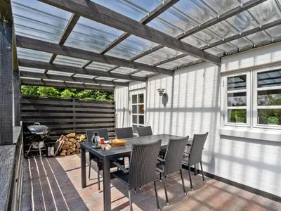 a patio with a table and chairs under a pergola at Holiday Home Minja - 900m from the sea by Interhome in Thisted