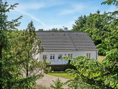 a white house in the middle of trees at Holiday Home Minja - 900m from the sea by Interhome in Thisted