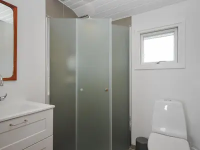 a bathroom with a toilet and a window at Holiday Home Engelbertine - 900m from the sea by Interhome in Thisted