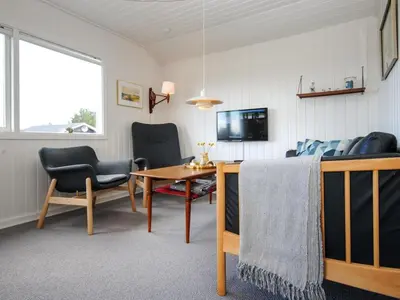a living room with a table and chairs and a couch at Holiday Home Engelbertine - 900m from the sea by Interhome in Thisted