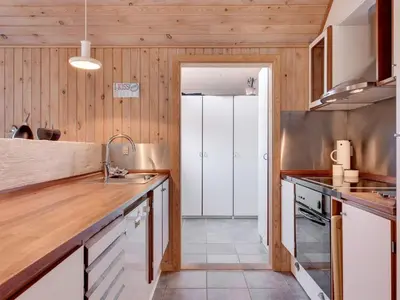 a kitchen with wooden walls and wooden counters at Holiday Home Bente - 800m from the sea by Interhome in Thisted