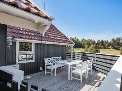 a wooden deck with a table and chairs on it at Holiday Home Bente - 800m from the sea by Interhome in Thisted