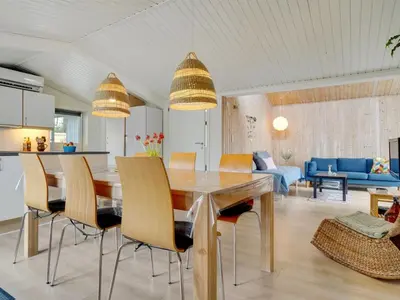 a dining room and living room with a table and chairs at Holiday Home Ljupka - 1km from the sea by Interhome in Thisted