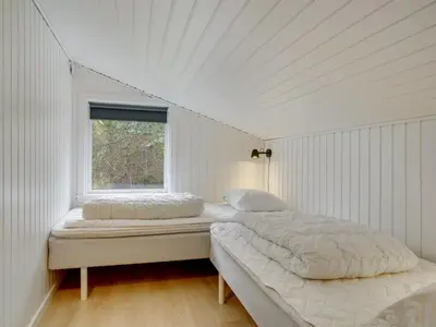 two beds in a white room with a window at Holiday Home Ljupka - 1km from the sea by Interhome in Thisted