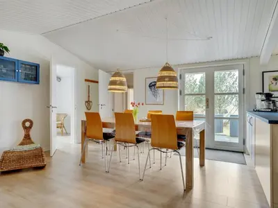 a kitchen and dining room with a table and chairs at Holiday Home Ljupka - 1km from the sea by Interhome in Thisted