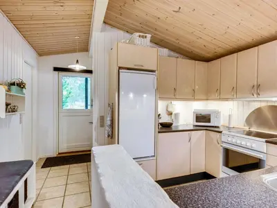 a kitchen with a white refrigerator in a room at Holiday Home Emeline - 1-7km from the sea by Interhome in Thisted