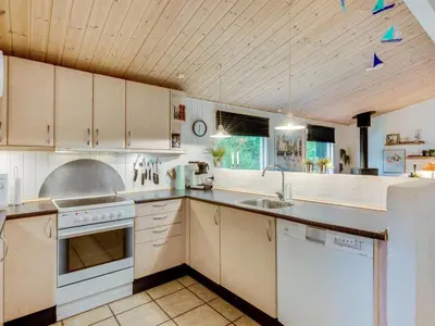 a large kitchen with white cabinets and a sink at Holiday Home Emeline - 1-7km from the sea by Interhome in Thisted