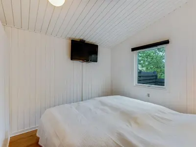 a white bedroom with a bed and a window at Holiday Home Emeline - 1-7km from the sea by Interhome in Thisted