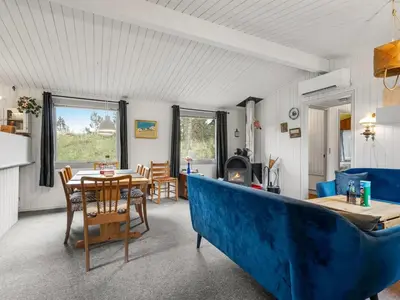 a living room with a table and a blue couch at Holiday Home Gundina - 2km from the sea by Interhome in Thisted