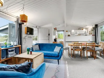 a living room with a blue couch and a table at Holiday Home Gundina - 2km from the sea by Interhome in Thisted
