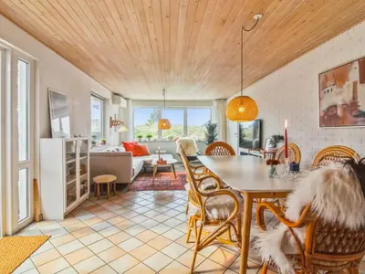 a dining room and living room with a table and chairs at Holiday Home Madsen - 500m from the sea by Interhome in Thisted