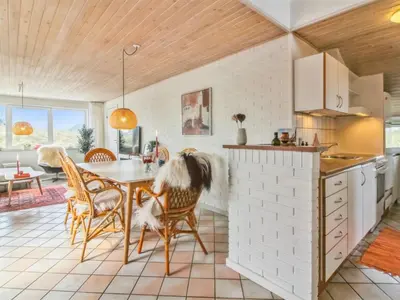 a kitchen and dining room with a table and chairs at Holiday Home Madsen - 500m from the sea by Interhome in Thisted